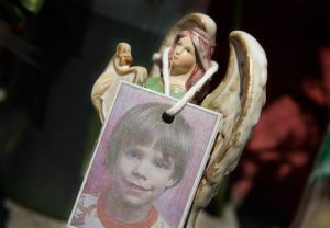FILE - A photograph of Etan Patz hangs on an angel figurine, as part of a makeshift memorial in the SoHo neighborhood of New York, May 28, 2012. (AP Photo/Mark Lennihan, File)