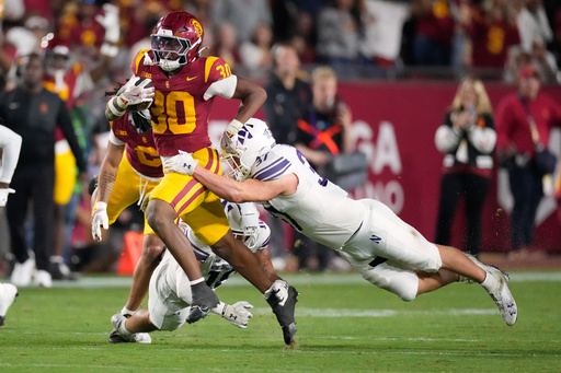 Southern California running back King Miller, left, breaks a tackle by Northwestern linebacker Mac Uihlein during the first half of an NCAA college football game Friday, Nov. 7, 2025, in Los Angeles. (AP Photo/Mark J. Terrill)