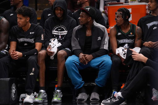 Minnesota Timberwolves guard Anthony Edwards, center, watches play during the first half of an NBA basketball game against the Denver Nuggets, Monday, Oct. 27, 2025, in Minneapolis. (AP Photo/Abbie Parr)
