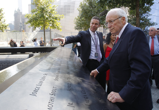 FILE - Former U.S. Vice President Dick Cheney, right, listens to 9/11 Memorial President Joe Daniels, center, as he looks at one of the panels inscribed with the names of the attack victims during a visit to the 9/11 memorial plaza in the World Trade Center site in New York Monday, Sept. 12, 2011, on the first day that the memorial was opened to the public. (AP Photo/Mike Segar, file)