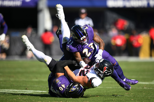 Houston Texans tight end Brenden Bates (82) is tackled by Baltimore Ravens linebacker Teddye Buchanan (40) and cornerback Jaire Alexander (23) during the second half of an NFL football game, Sunday, Oct. 5, 2025, in Baltimore. (AP Photo/Nick Wass)