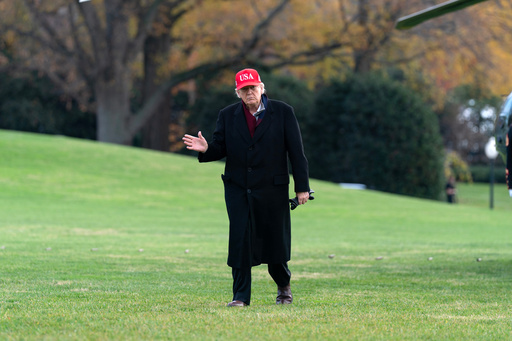 President Donald Trump waves to the media as he walks in the South Lawn upon his arrival to the White House, Saturday, Nov. 22, 2025, in Washington. (AP Photo/Jose Luis Magana)