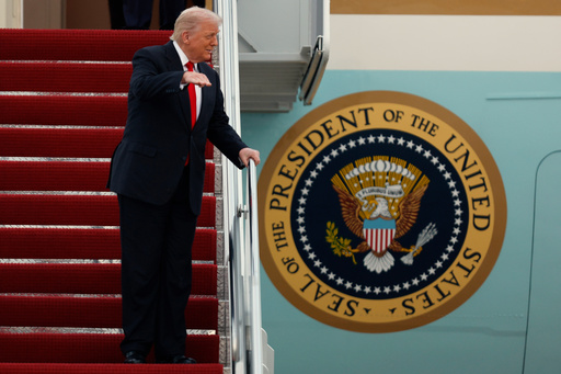 President Donald Trump gestures toward the media as he walks down the stairs of Air Force One upon his arrival at Joint Base Andrews, Md., Sunday, Nov. 9, 2025, after returning from his Mar-a-Lago estate in Palm Beach, Fla. and en route to an NFL football game between the Washington Commanders and the Detroit Lions. (AP Photo/Luis M. Alvarez)