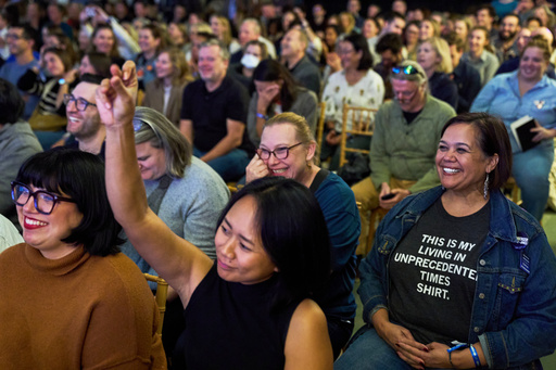 Micaela Mejia Pond, right, and other attendees of Crooked Con, cheer while listening to Sen. Ruben Gallego, D- Ariz., speak, Friday, Nov. 7, 2025, in Washington. (AP Photo/Jacquelyn Martin)