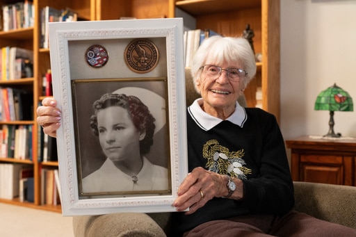 Alice Darrow shows a photo of herself from when she was a nurse during World War II, Thursday, Oct. 23, 2025, at her home in Danville, Calif. (AP Photo/Laure Andrillon)